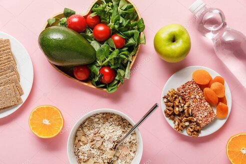 Assiette colorée composée de légumes, de fruits et de céréales complètes pour la santé du cœur.